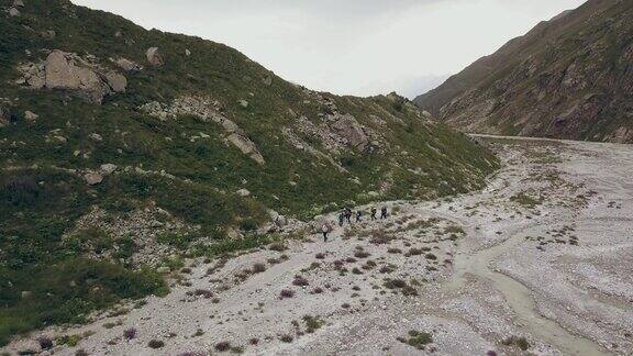 鸟瞰旅游团行走在山间小径上的背景山峰