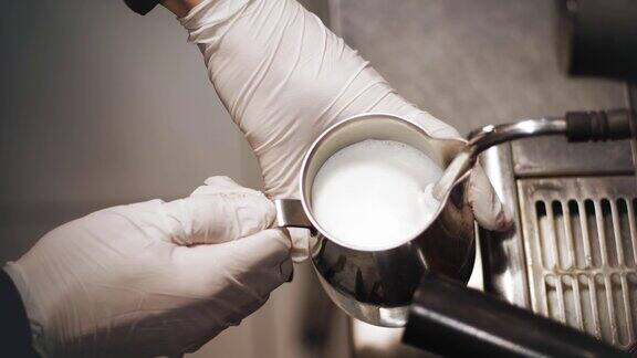 专业的咖啡酿造特写镜头咖啡师在咖啡机里给牛奶起泡制作艺术拿铁