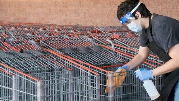 超市员工戴着口罩和乳胶手套为购物车消毒防止传染