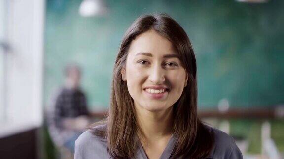 美丽的亚洲女人在现代办公室的肖像年轻成功的女商人微笑着看着镜头