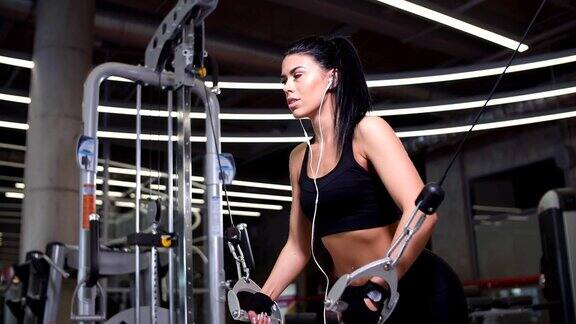 肖像妇女锻炼电力电缆交叉的胸部肌肉在健身房