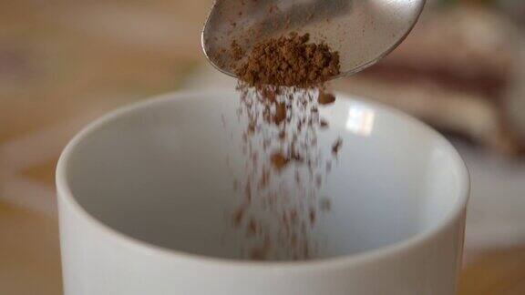 速溶咖啡碎片从勺子在杯子中的慢动作新鲜早晨热巧克力近缓慢的运动咖啡粉从勺子上掉下来可可早上特写镜头