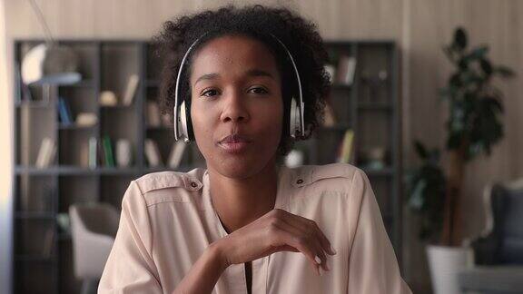 非洲女性戴着耳机使用视频通话应用程序与对话者交谈