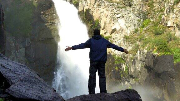 一个旅行者站在瀑布前