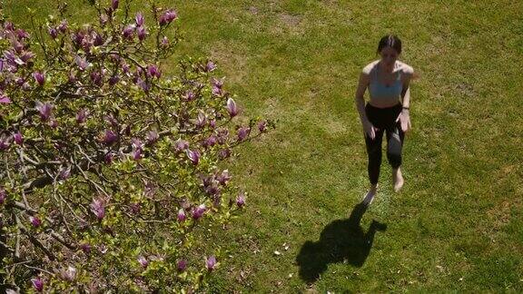 一名年轻女子在禁闭期间在家花园里锻炼