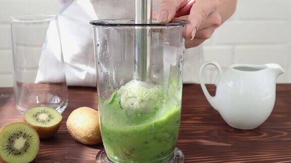用搅拌机磨菠菜加蔬菜奶的冰沙