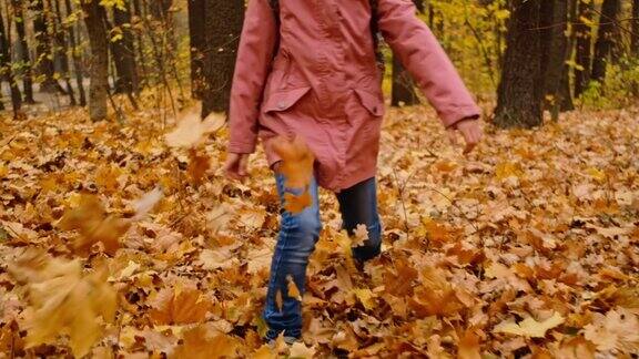 女孩用脚扔树叶