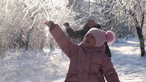 在一个美好的冬日祖母带着孙女在雪中漫步