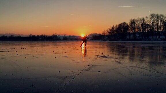 曲棍球运动员在结冰的湖面上滑向夕阳