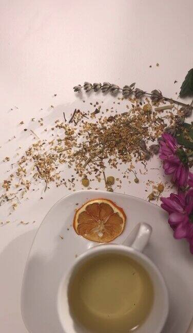 高角度的陶瓷茶杯在桌子上桌子上有草药蜂蜜罐鲜花