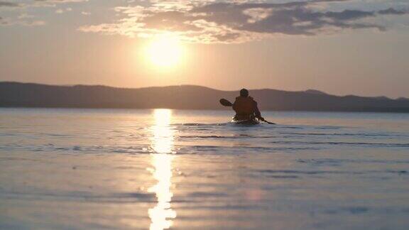 在日落时划着皮划艇