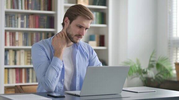一名男子在笔记本电脑上打字时颈部疼痛