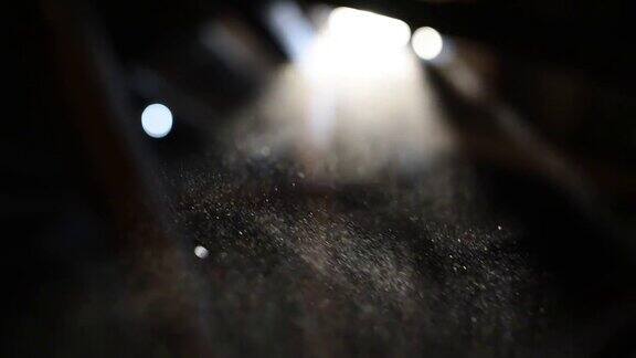 浮尘颗粒与耀斑在黑色背景在慢动作