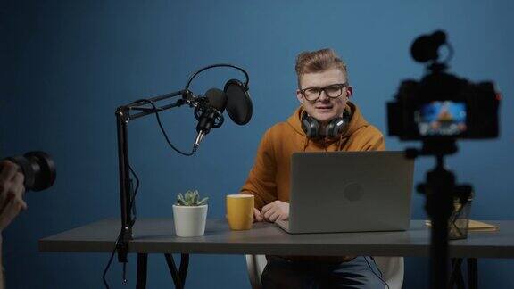一位年轻的天才dj坐在他的工作室里用直播录制他的播客