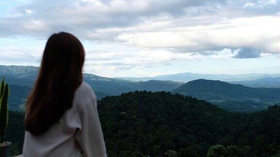模糊的背面一个女旅行者看一个美丽的山景