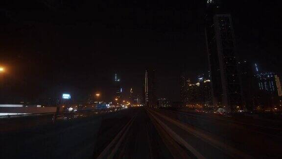 迪拜地铁在夜间驶过市中心的摩天大楼地铁列车在地铁轨道上快速行驶的第一人称视角