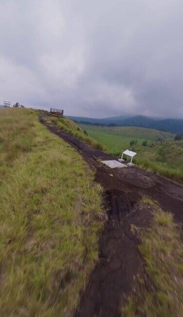 垂直视频Fpv无人机绿色山峰地面土路山脊边缘