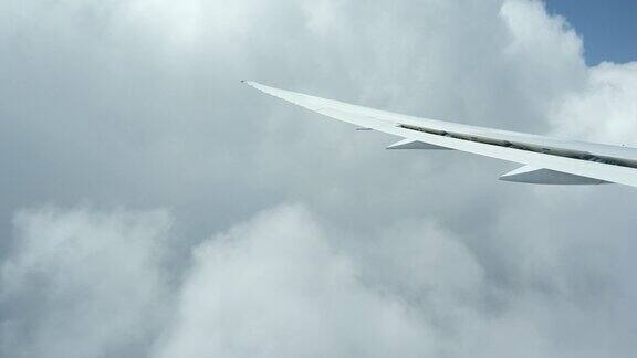 飞机机翼在乱流中穿过云层和天空