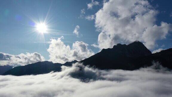 鸟瞰图移动的云雾运动与太阳和蓝天在奥地利的山脉