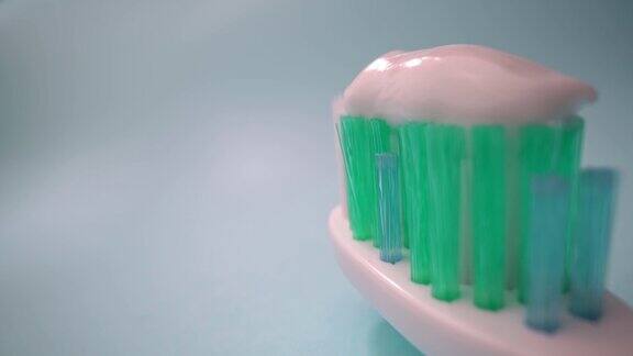 极端微距拍摄牙刷在蓝色背景上运动牙刷上有牙膏向前移动特写