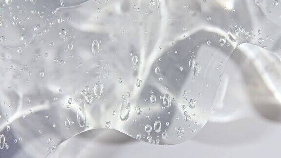 透明化妆品凝胶液白色表面上有气泡流下微距镜头