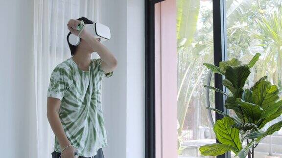 亚洲男子使用VR眼镜在家庭办公室玩游戏