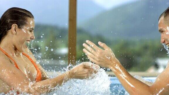 高清超级慢动作:一对夫妇在泳池里泼水