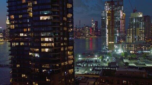 在布鲁克林绿点和皇后区猎人角的海滨新建豪华公寓的夜景航拍视频与后向摄像机运动