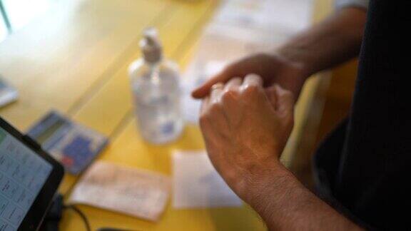 企业家使用酒精凝胶清洁和洗手在他的小公司