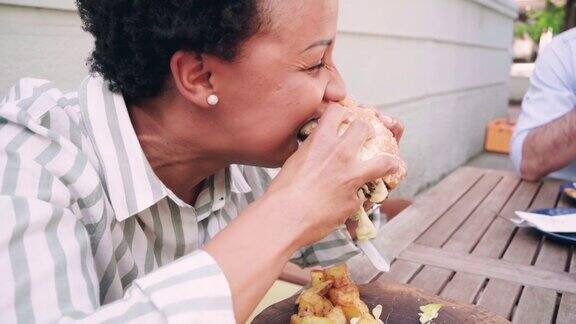 非裔美国中年妇女在餐厅吃汉堡