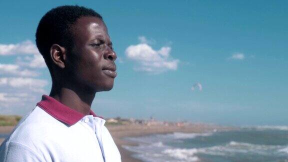 孤独悲伤的非洲黑人青年在海滩上失踪移民