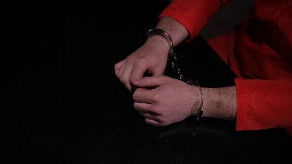 穿着橙色囚服戴着手铐的男囚犯