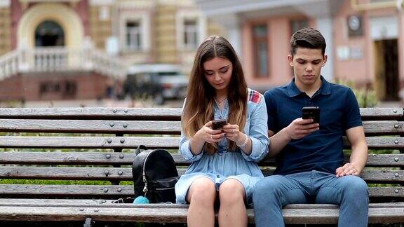 情侣们在户外玩手机