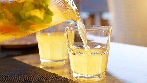 柠檬水加橙、薄荷和冰倒入玻璃杯