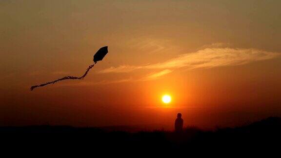 小男孩在日落放风筝