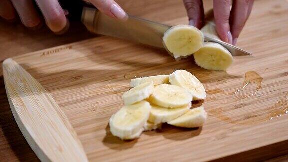 在切菜板上切香蕉的女人的特写
