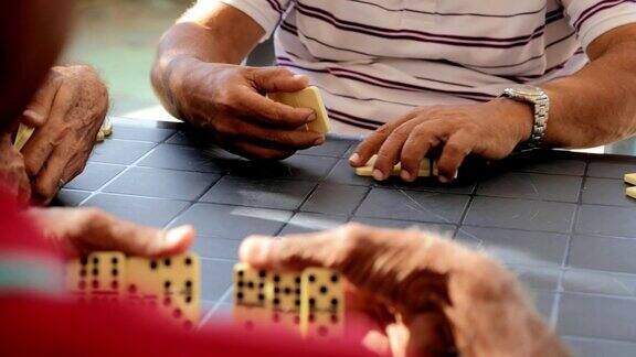 一群老年人在玩多米诺骨牌游戏
