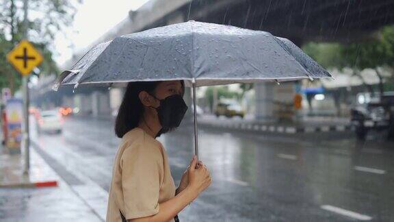 一个亚洲女人在雨中等出租车