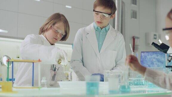 孩子们在做科学实验实验室内部浇注多种颜色的液体
