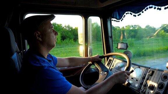 傍晚一辆卡车在乡间行驶戴着帽子的男人控制着他的卡车享受着旅程查看车厢内运输的物流概念慢镜头