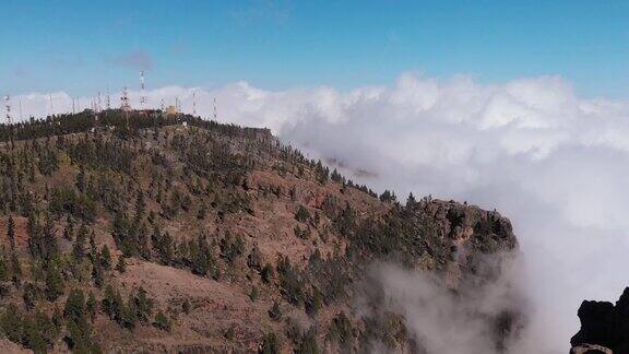 鸟瞰图-发射塔位于群山之中云层之上松林周围