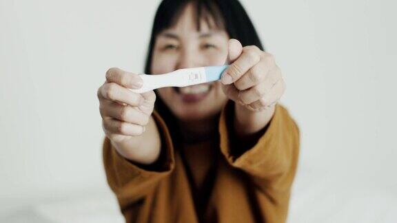 怀孕测试呈阳性的快乐女人
