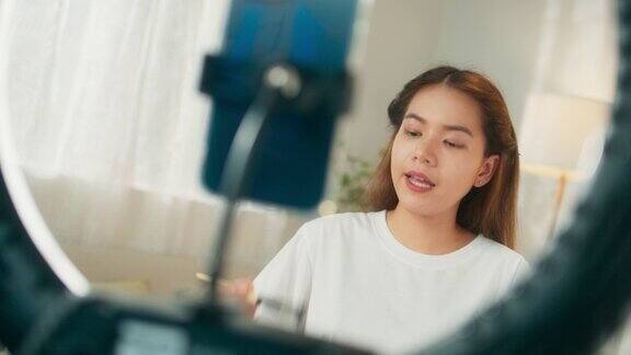 有吸引力的年轻亚洲女性网红在移动应用程序上在线直播分享化妆技巧