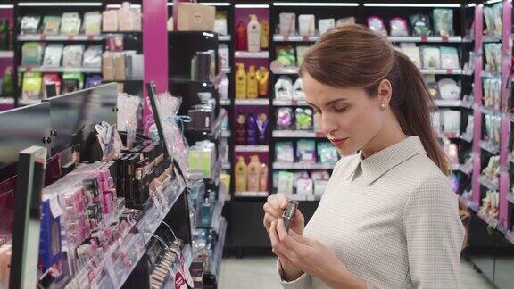 漂亮女人在化妆品店选择口红