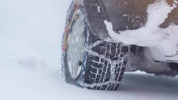 观点冬天的轮胎在下雪的路上行驶给轮胎上链子冬天的道路安全