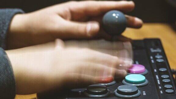 按街机键盘上的彩色按钮来玩老式电子游戏的男孩