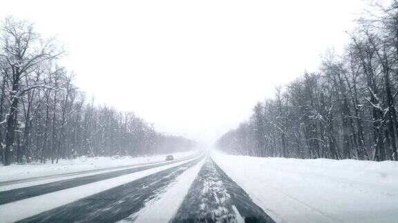 开车行驶在冬季积雪的马路上