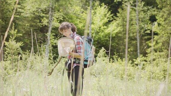 一名年轻女子在森林空地上检查蚊帐