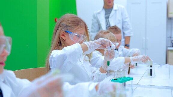 老师和学生在学校教室里做科学实验化学课上的孩子们