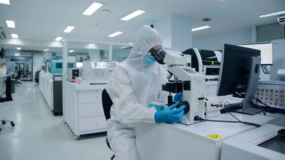 穿着防护服的科学家正在使用显微镜慢镜头
